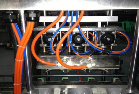 vacuum capper linear Gros plan d'une partie des têtes de capsulage sous vide.jpg